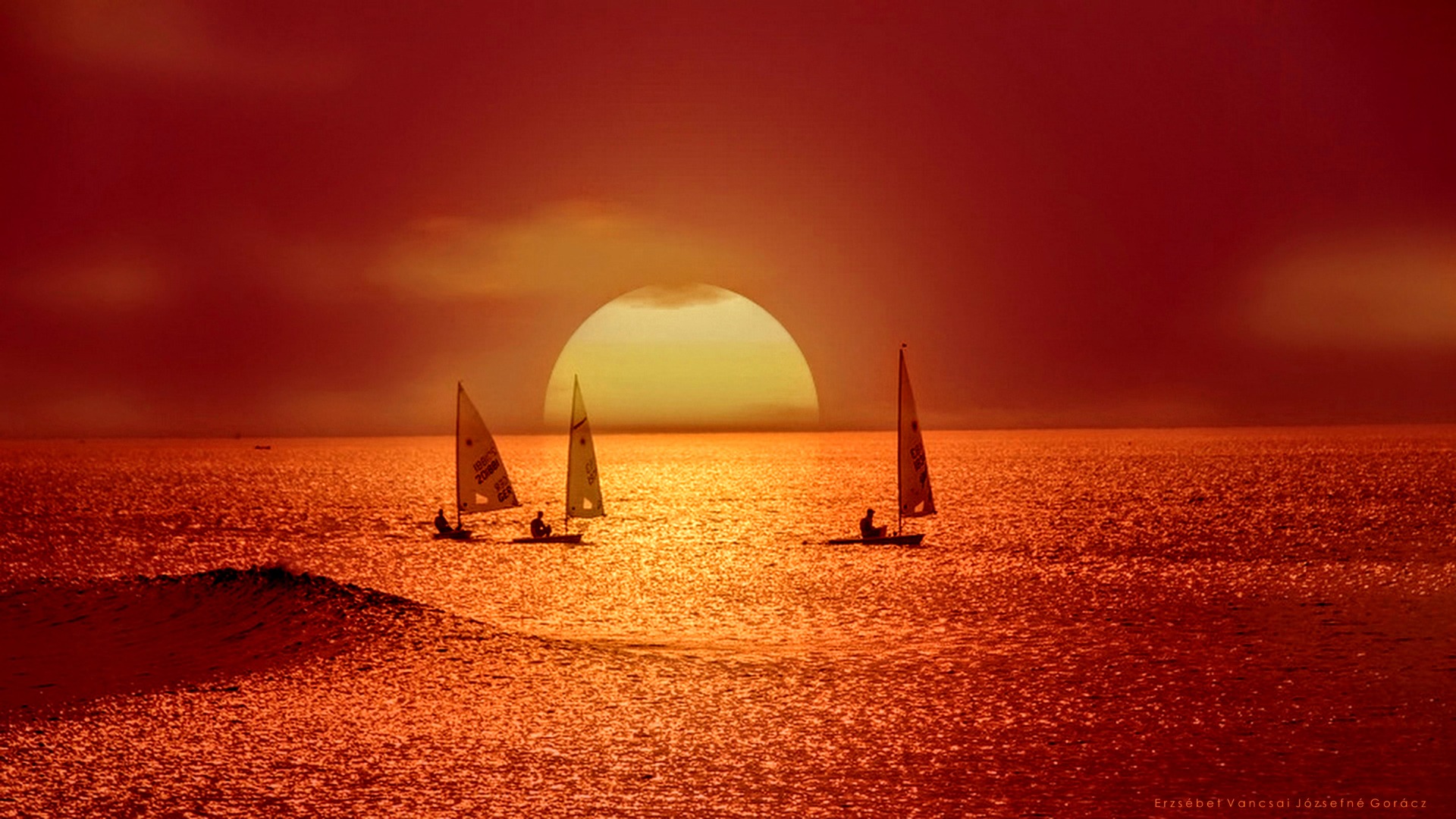 Vitorlások a vörös naplementében